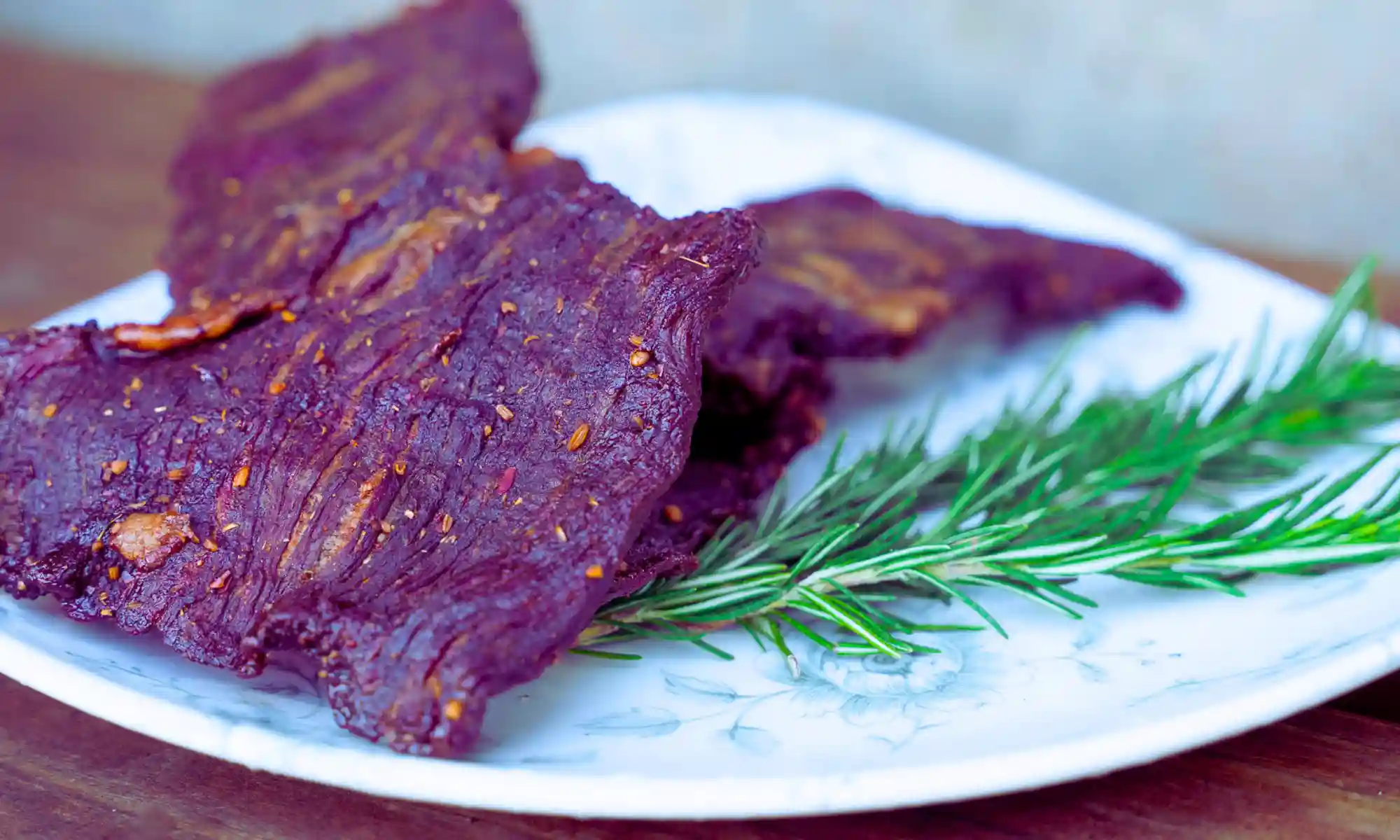 Prepared ethically raised meat with rosemary on a plate