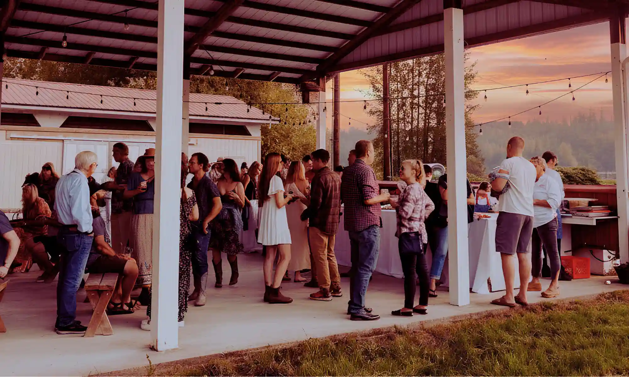 Guests at a covered farm event space during a seasonal gathering