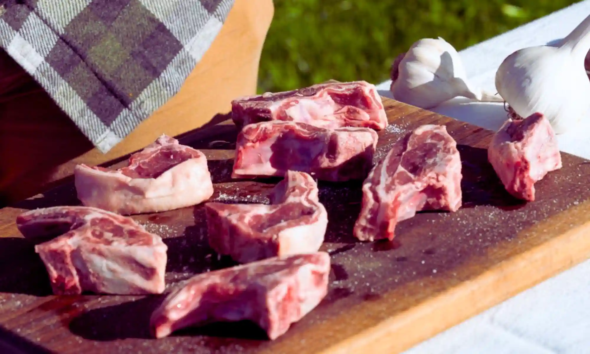 Fresh sheep meat cuts on a board with garlic