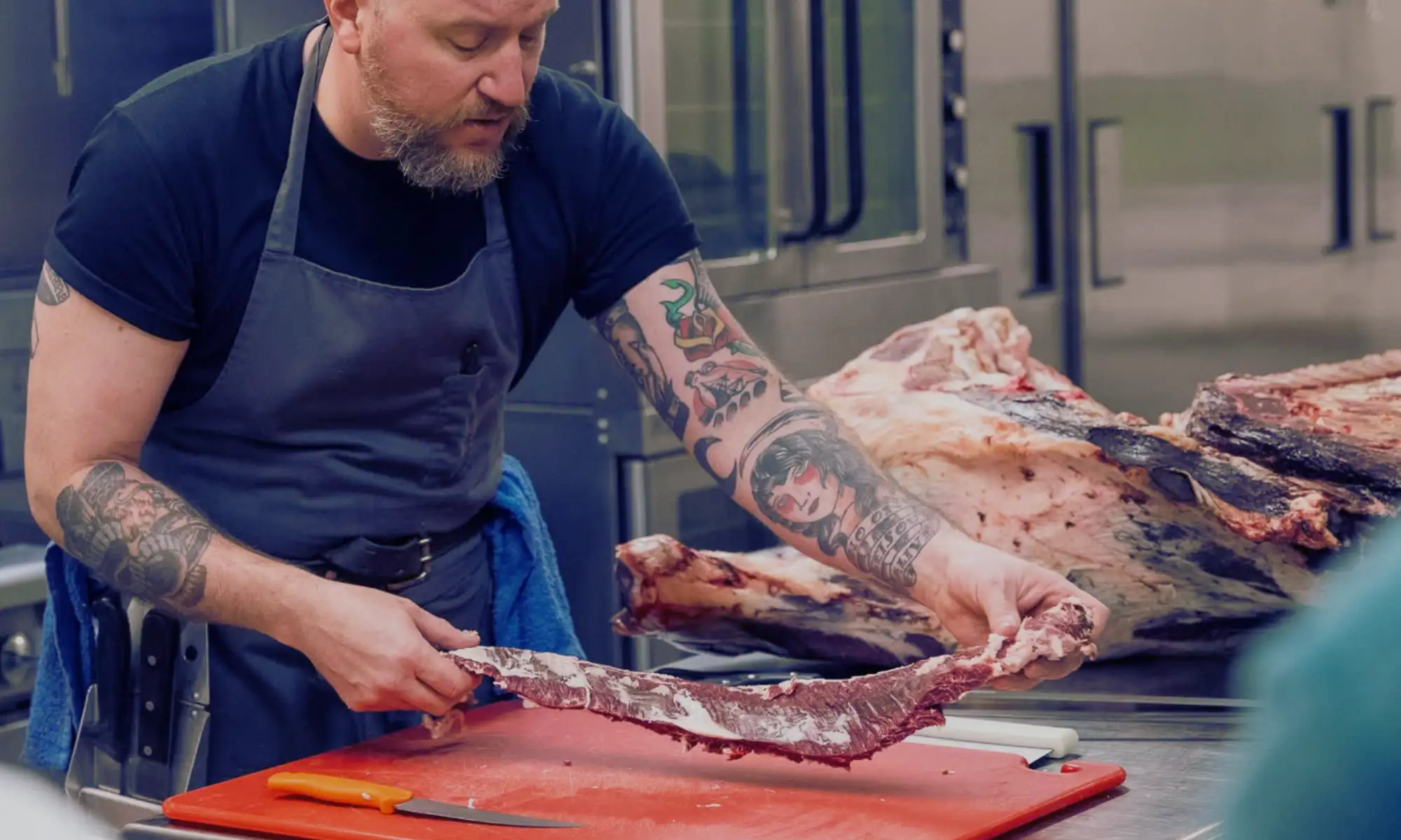 Butcher preparing a fresh cut of meat at the Carnation Farms Butcher Counter