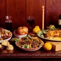 Thanksgiving catering table at Carnation Farms with roasted squash, salad, rolls, wine, candles, and holiday sides in Carnation, WA.